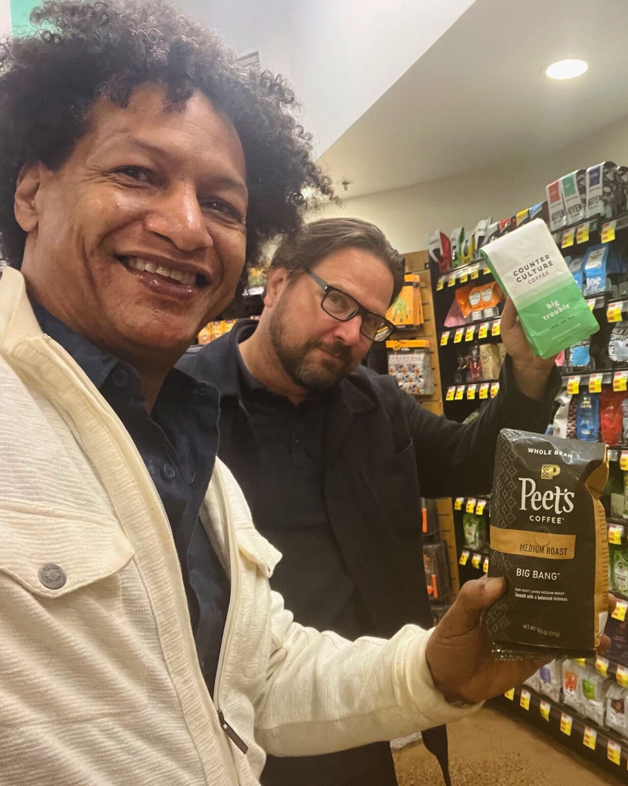 LaRon with a colleague holding coffee bags in a grocery aisle